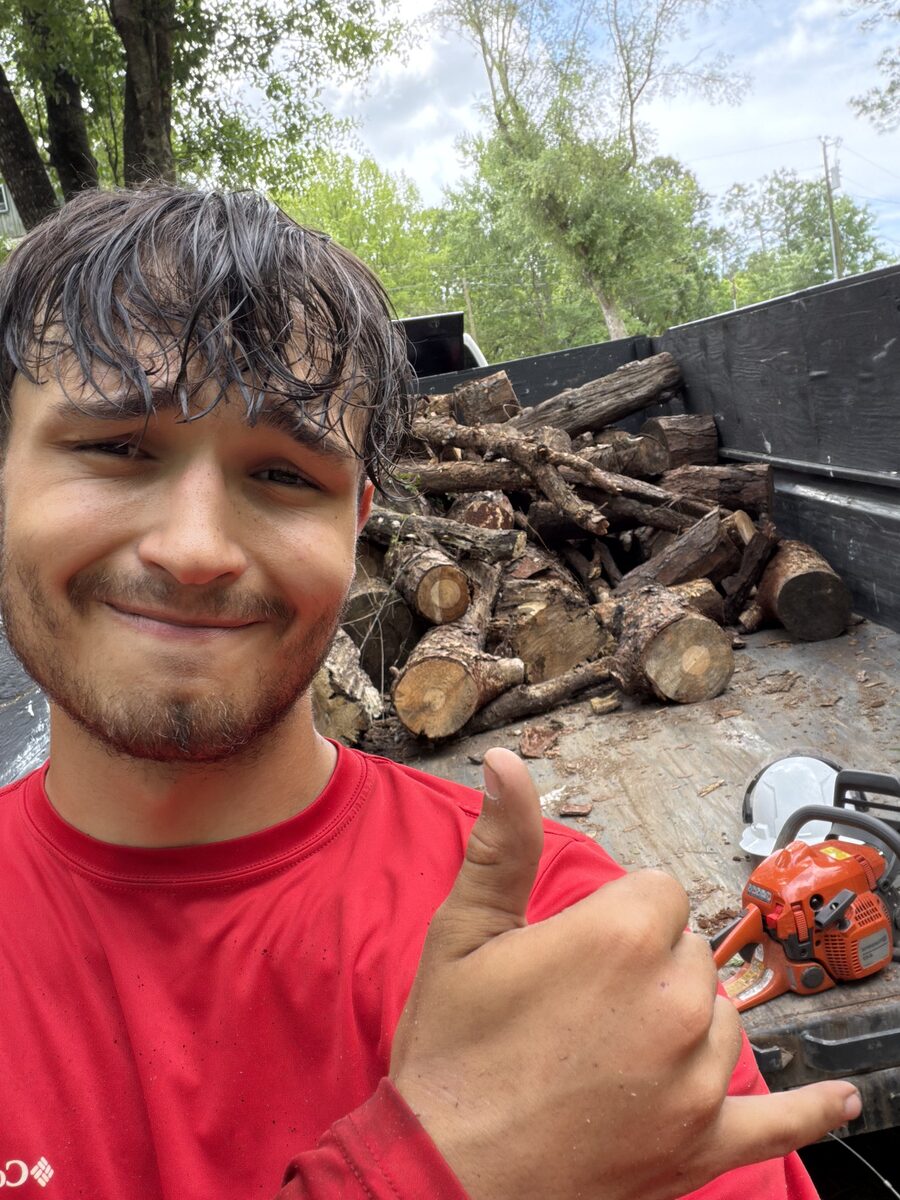Marucci Enterprises crew member beside a dump trailer loaded with cut wood