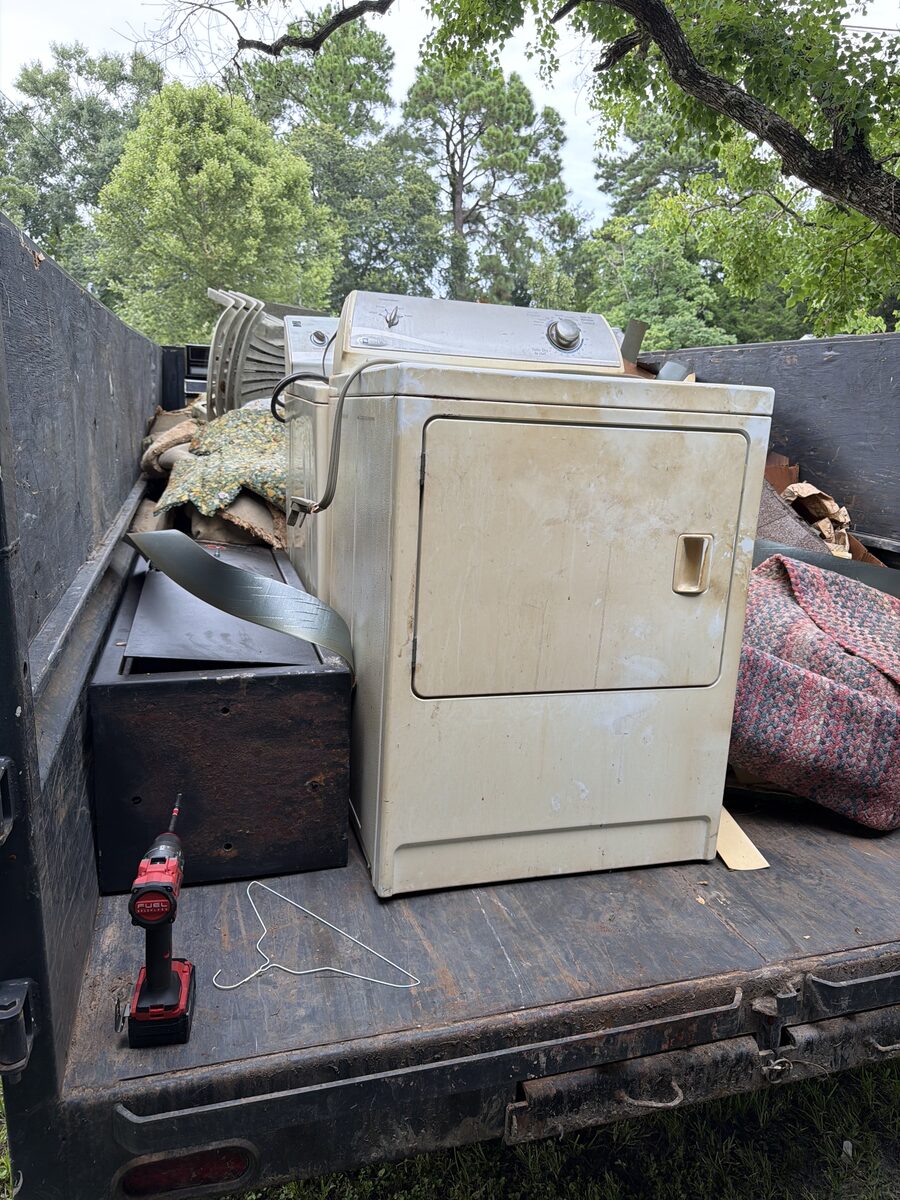 Appliances and household items loaded into a dump trailer for removal
